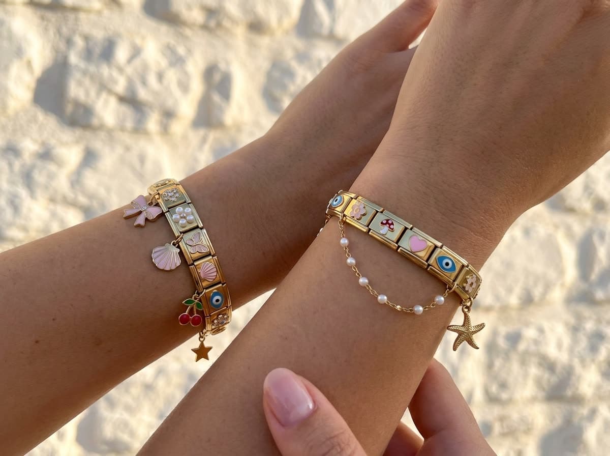 Zwei Frauenhandgelenke nebeneinander vor einer sonnigen Wand, an jedem ein Charm-Armband